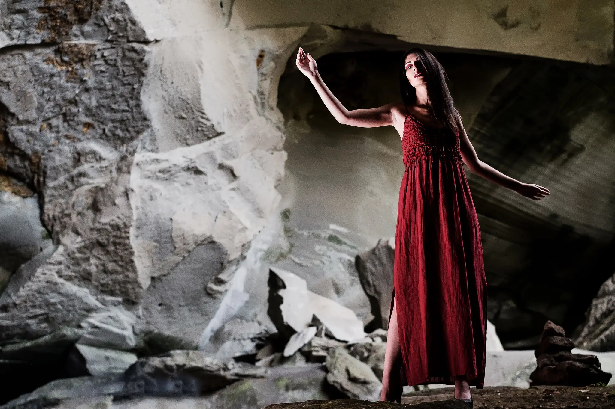 Portrait shoot of a model in red dress inside a cave