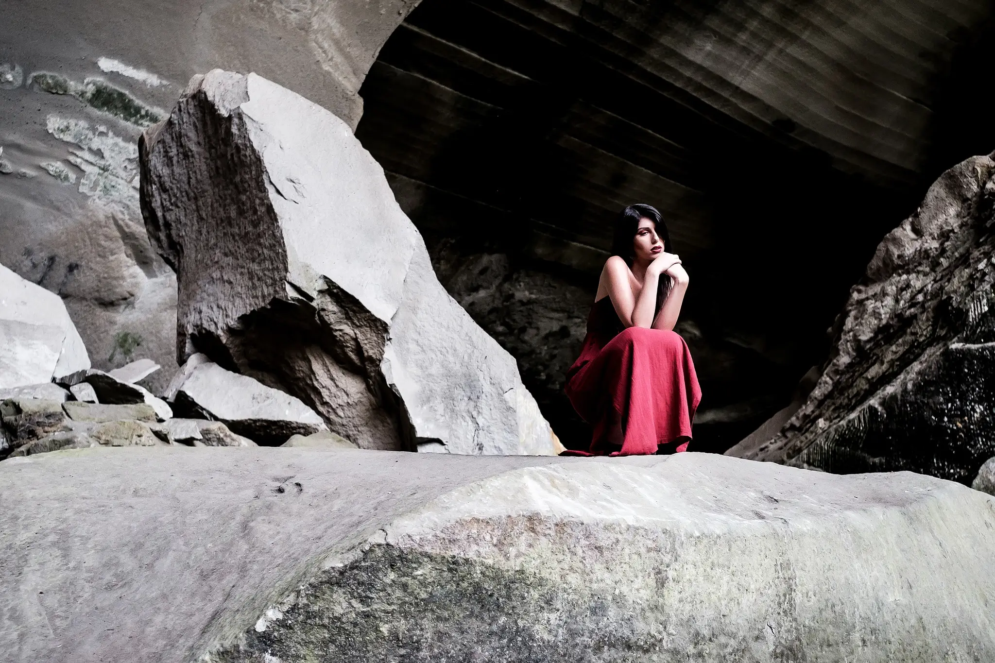 Portrait shoot of a model in red dress inside a cave