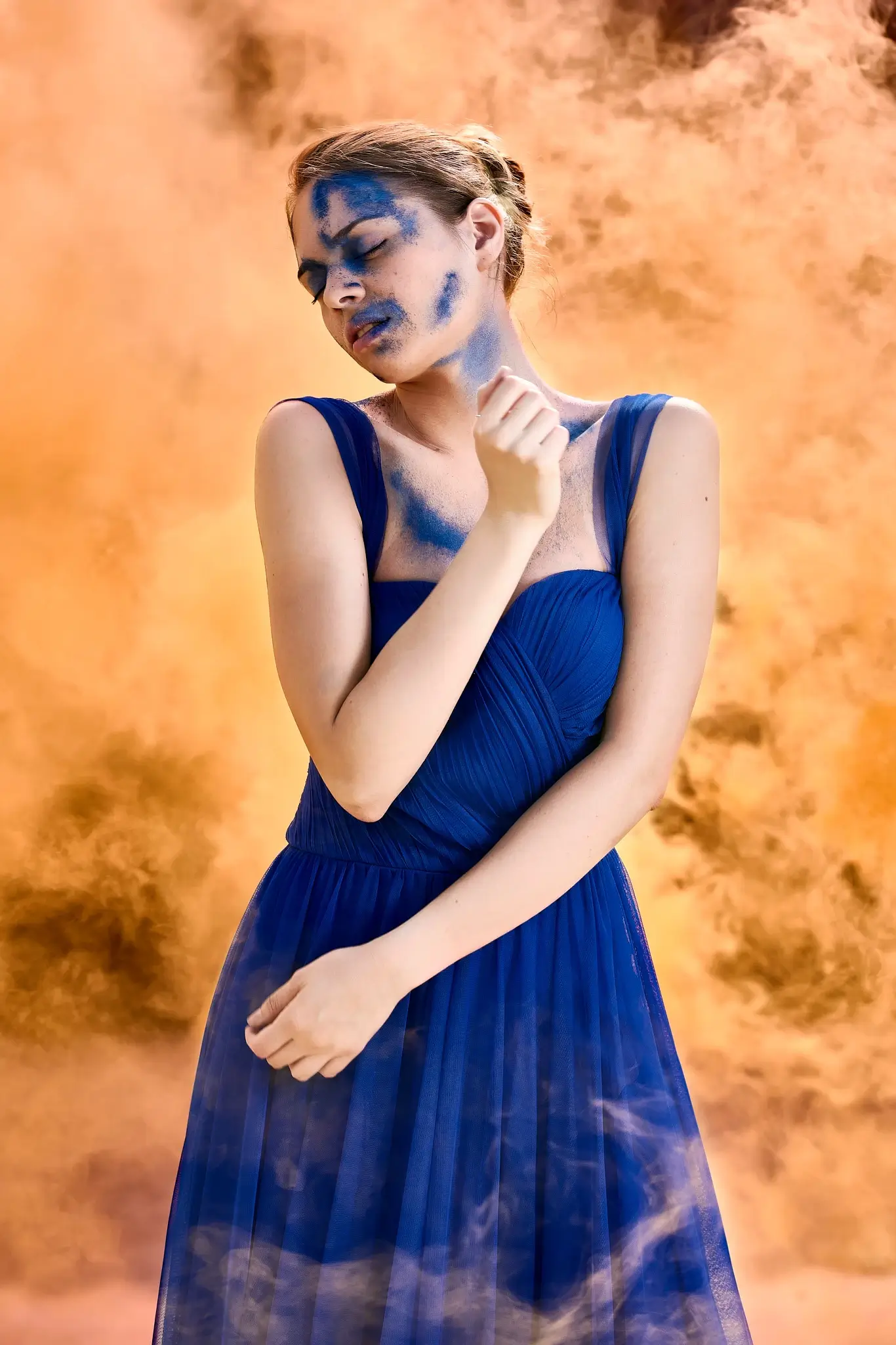 Unpublished - Portrait of model in blue dress with orange smoke