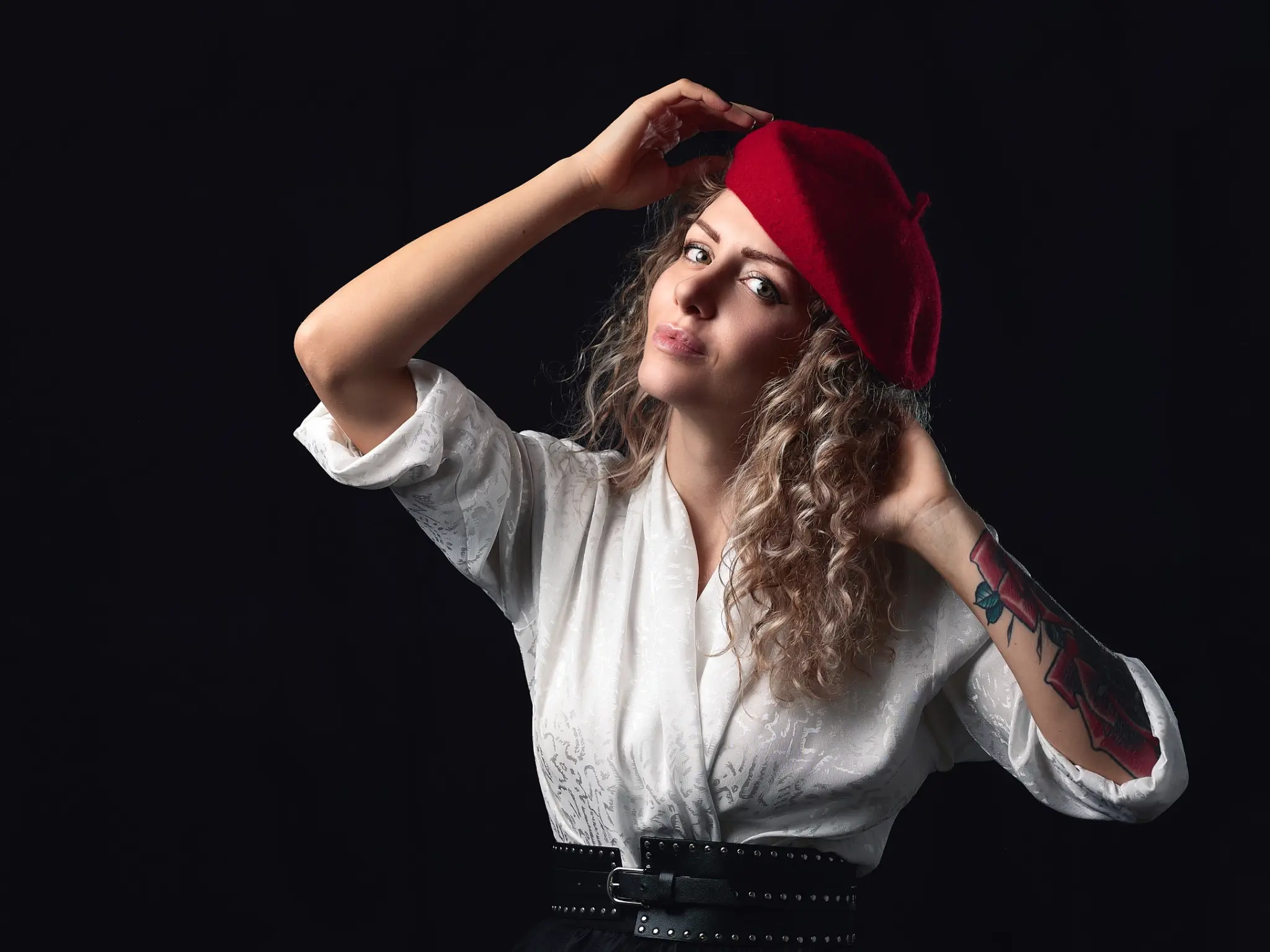 Studio portrait photograph of blonde model with white shirt and red hat