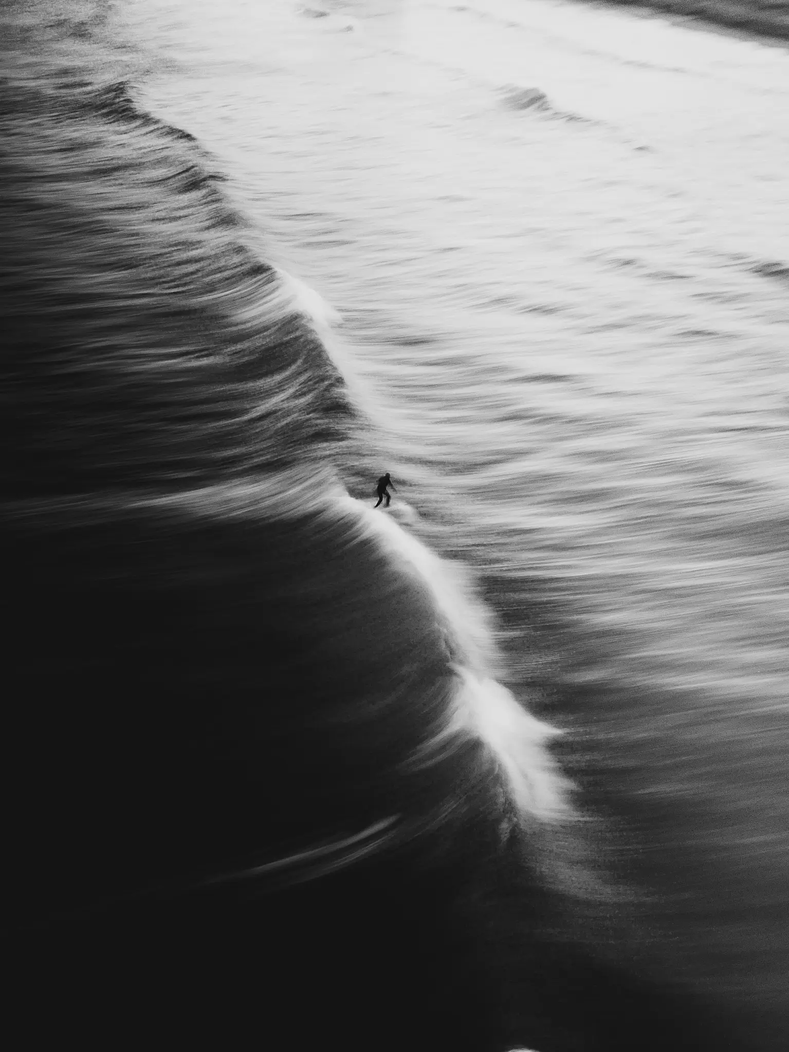 Black and whitre shot of a surfer on a long exposure