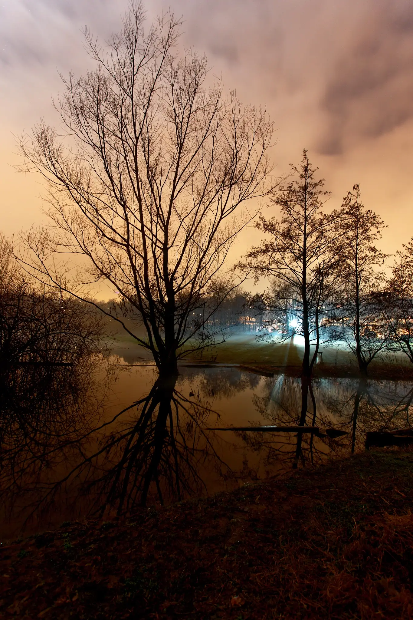 Night photography on the lake with eerie lights from thew city