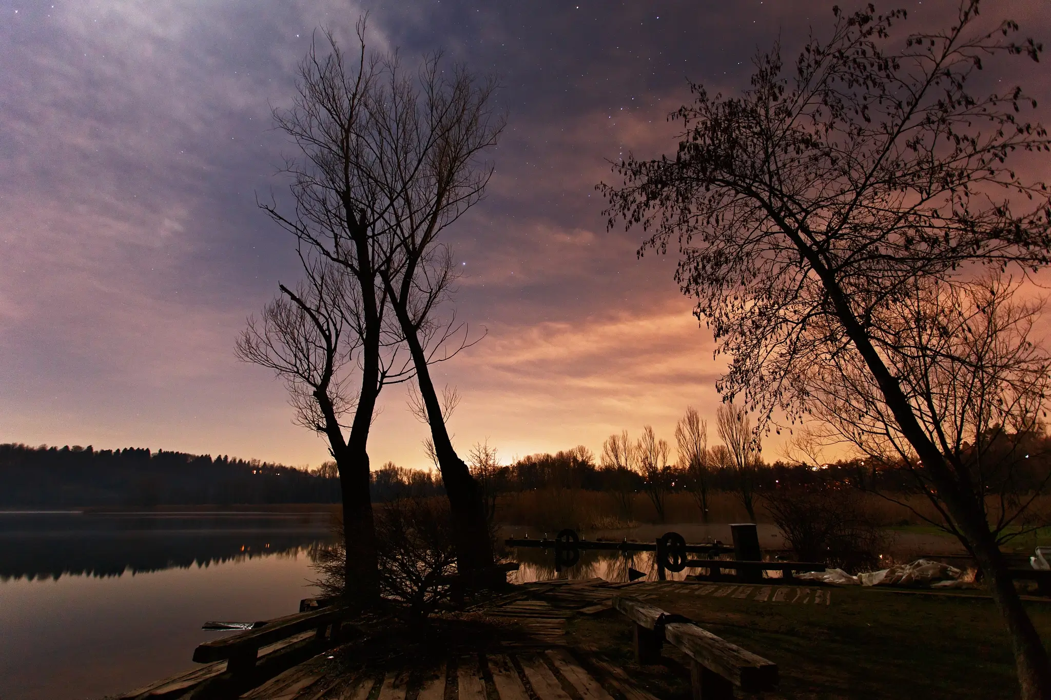 Night photography on the lake with eerie lights from thew city