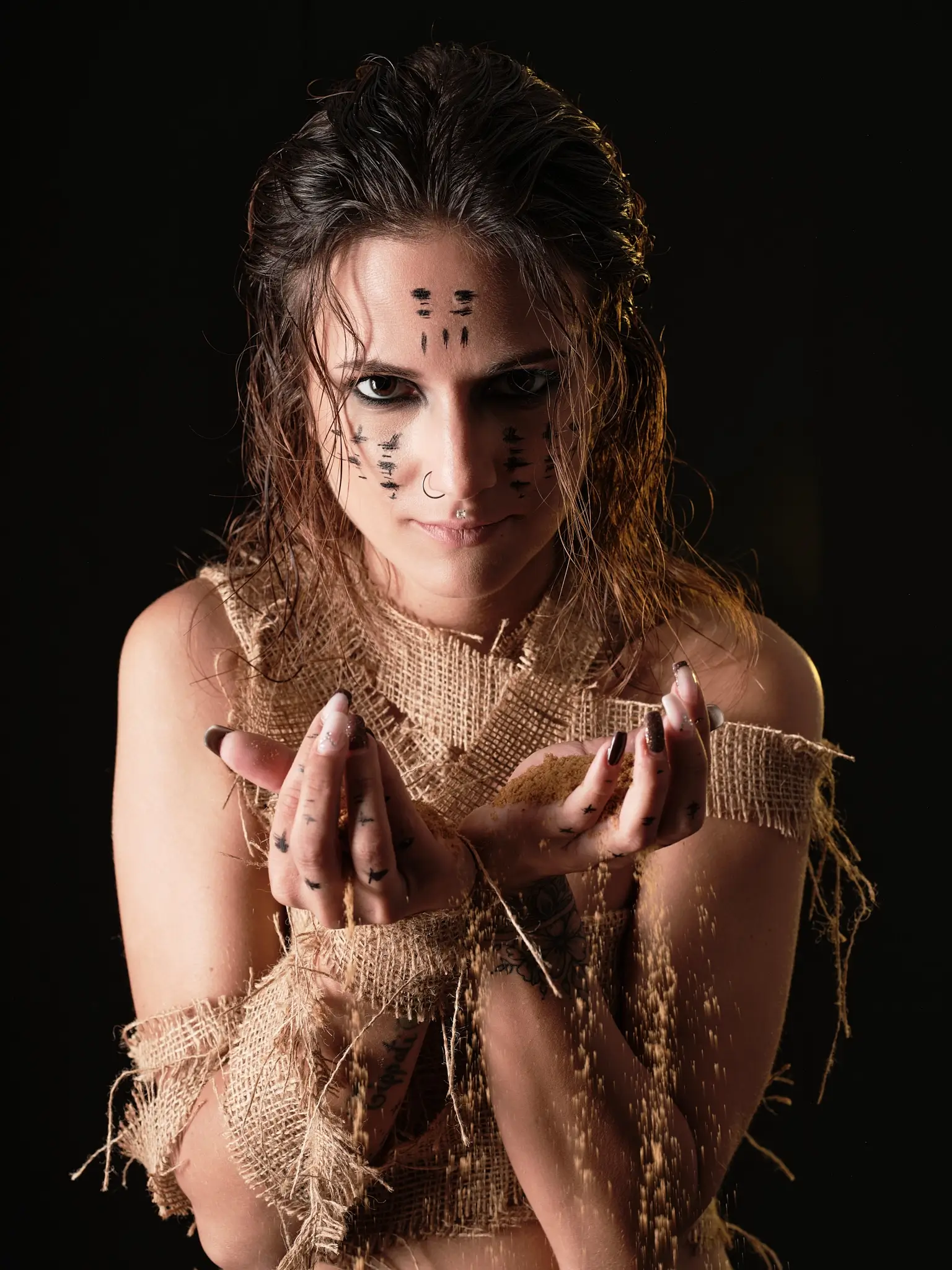 Hands holding flowing sand in a photoshoot with lights