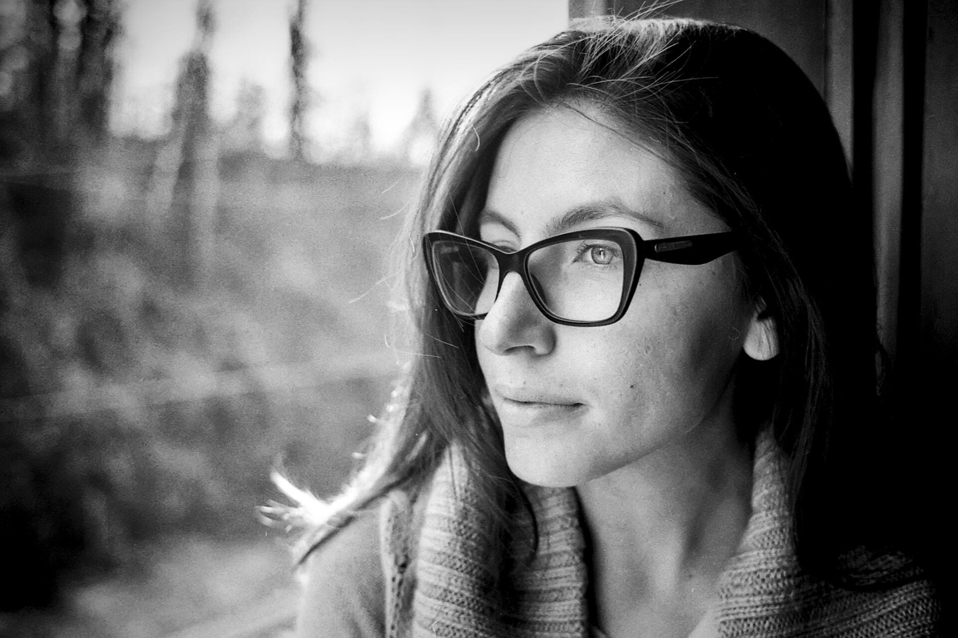 Ritratto in bianco e nero su film di modella con sguardo sognante e occhiali neri Ritratto in bianco e nero su film di modella con sguardo sognante e occhiali neri