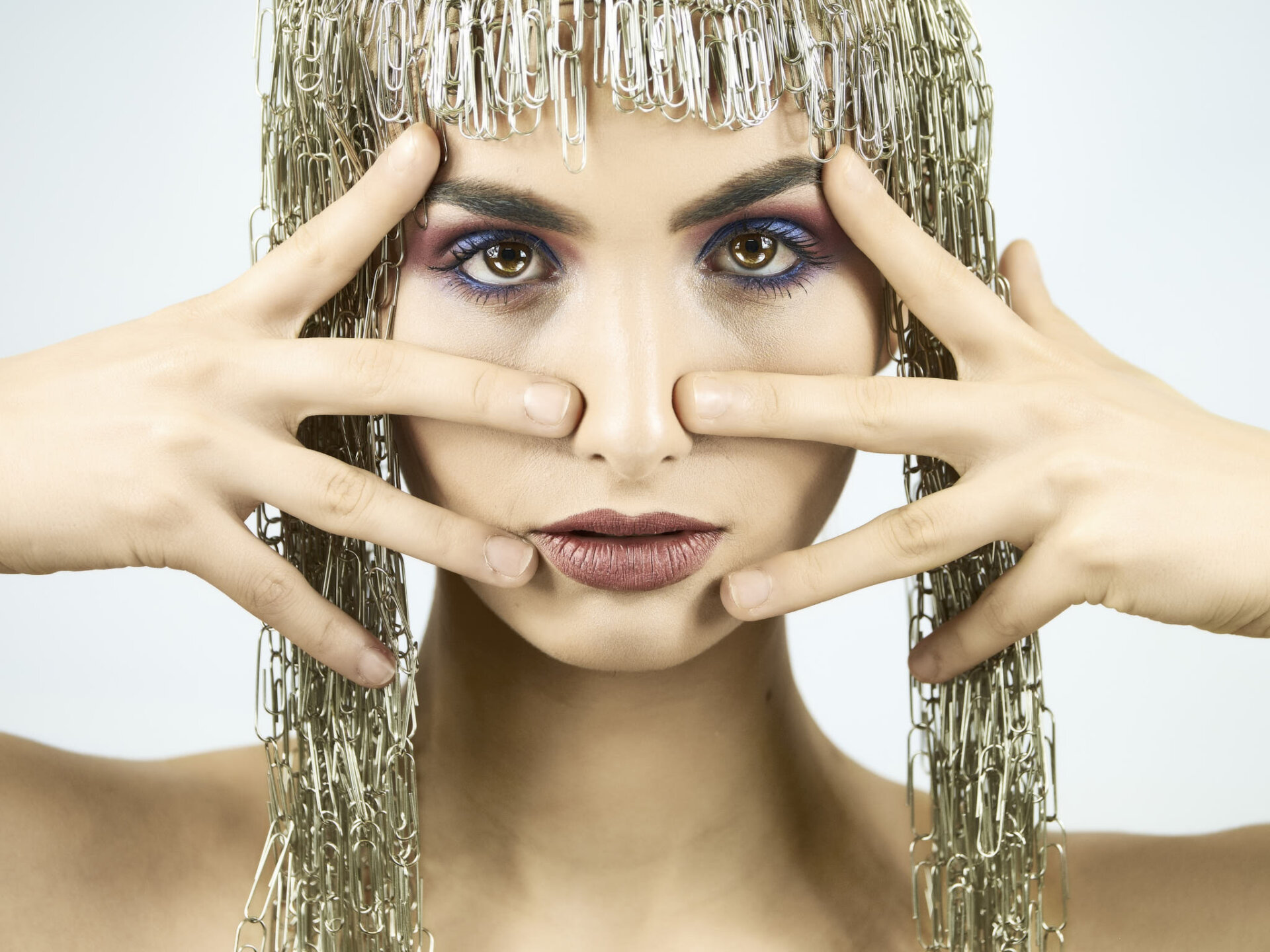 Ritratto beauty di modella con makeup blu e viola e parrucca di graffette