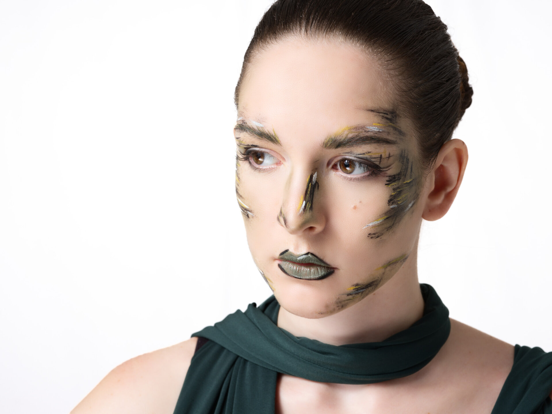 Ritratto beauty di modella con makeup a pennellate e abito verde