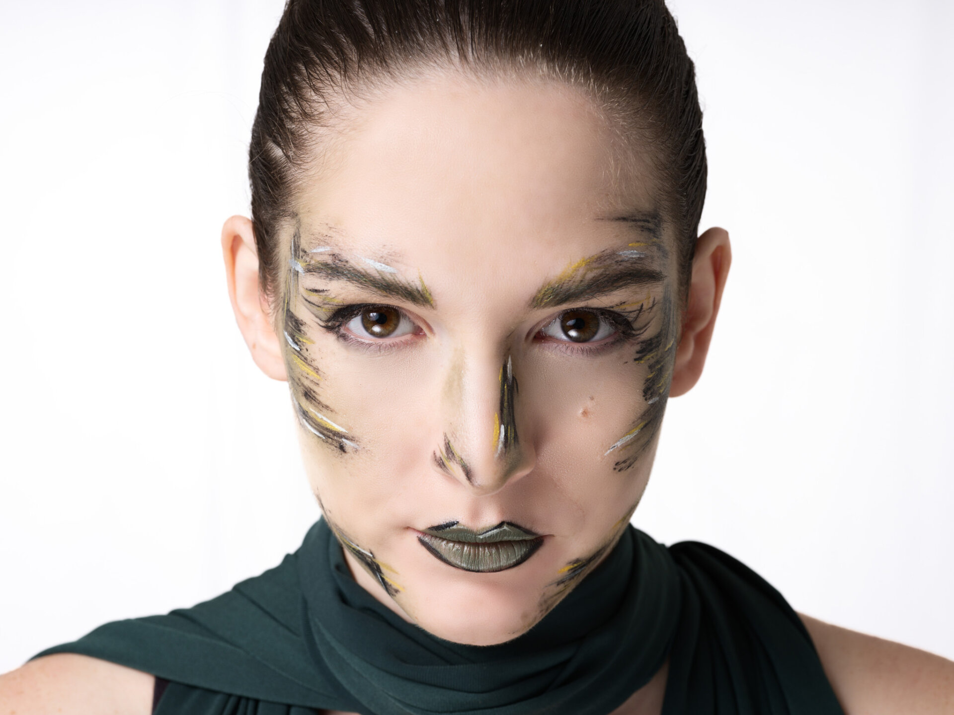 Ritratto beauty di modella con makeup a pennellate e abito verde