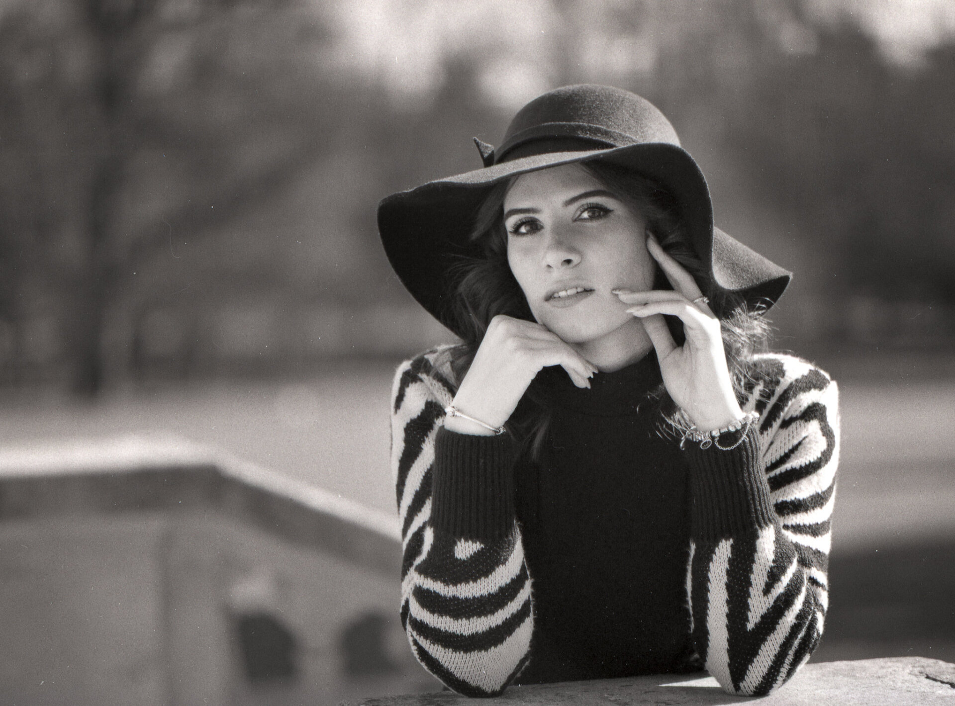 Ritratto in bianco e nero su film di modella con maglia a righe e grande cappello nero Ritratto in bianco e nero su film di modella con maglia a righe e grande cappello nero